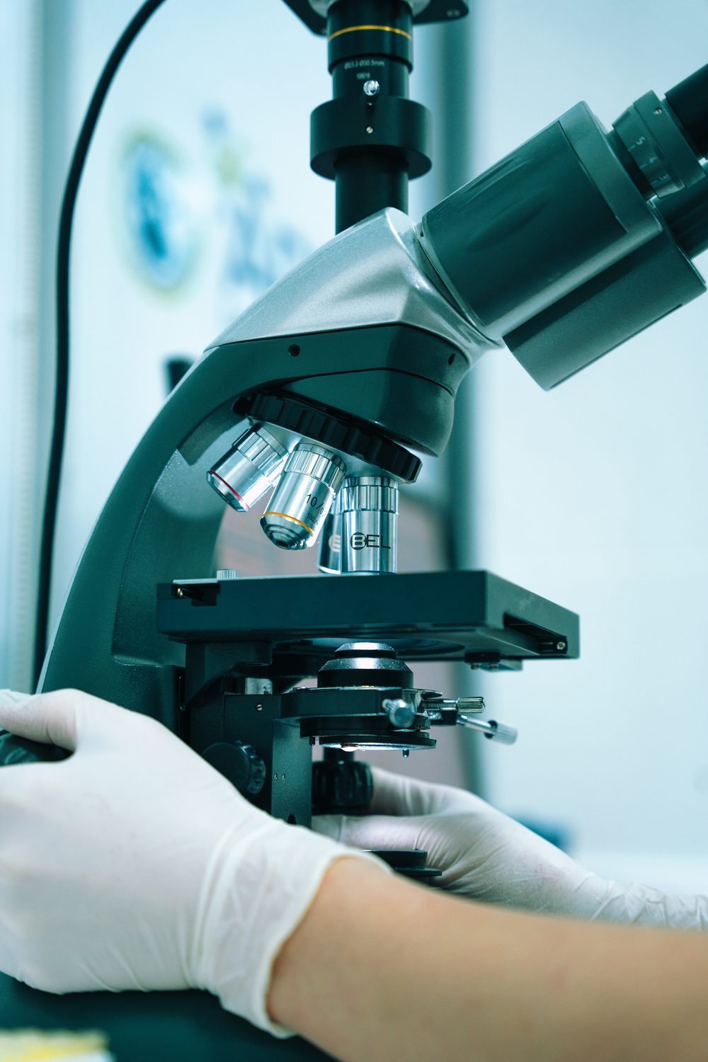 Een laboratoriummedewerker achter een microscoop